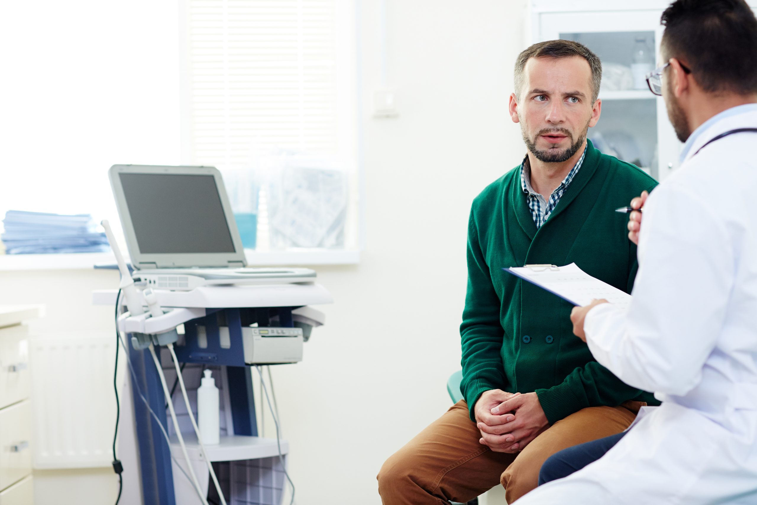 Serious patient listening to advice of professional practitioner after examination